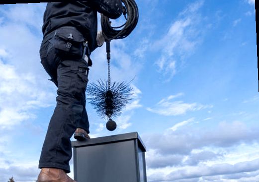 Technician servicing a prefab chimney chase with a flue brush in Lakewood NJ